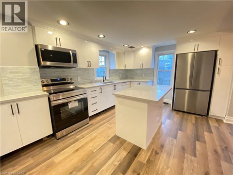A modern kitchen with white cabinets and stainless steel appliances.