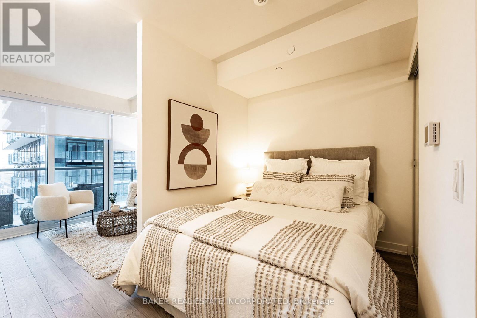 A bedroom with a large bed and a chair by the window.