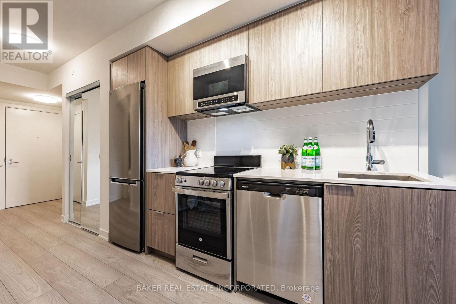 A modern kitchen with wooden cabinets and stainless steel appliances.
