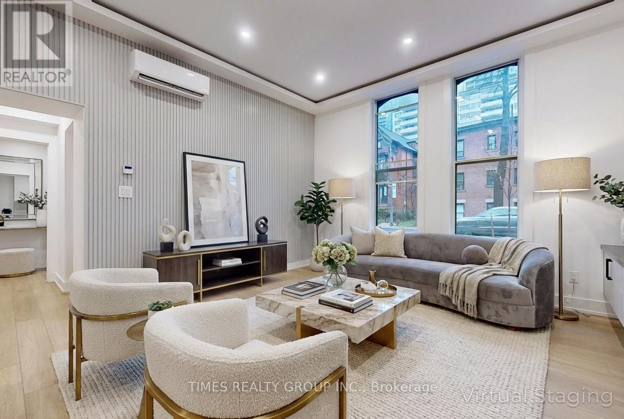 A living room with a grey couch, a coffee table, and a large window.