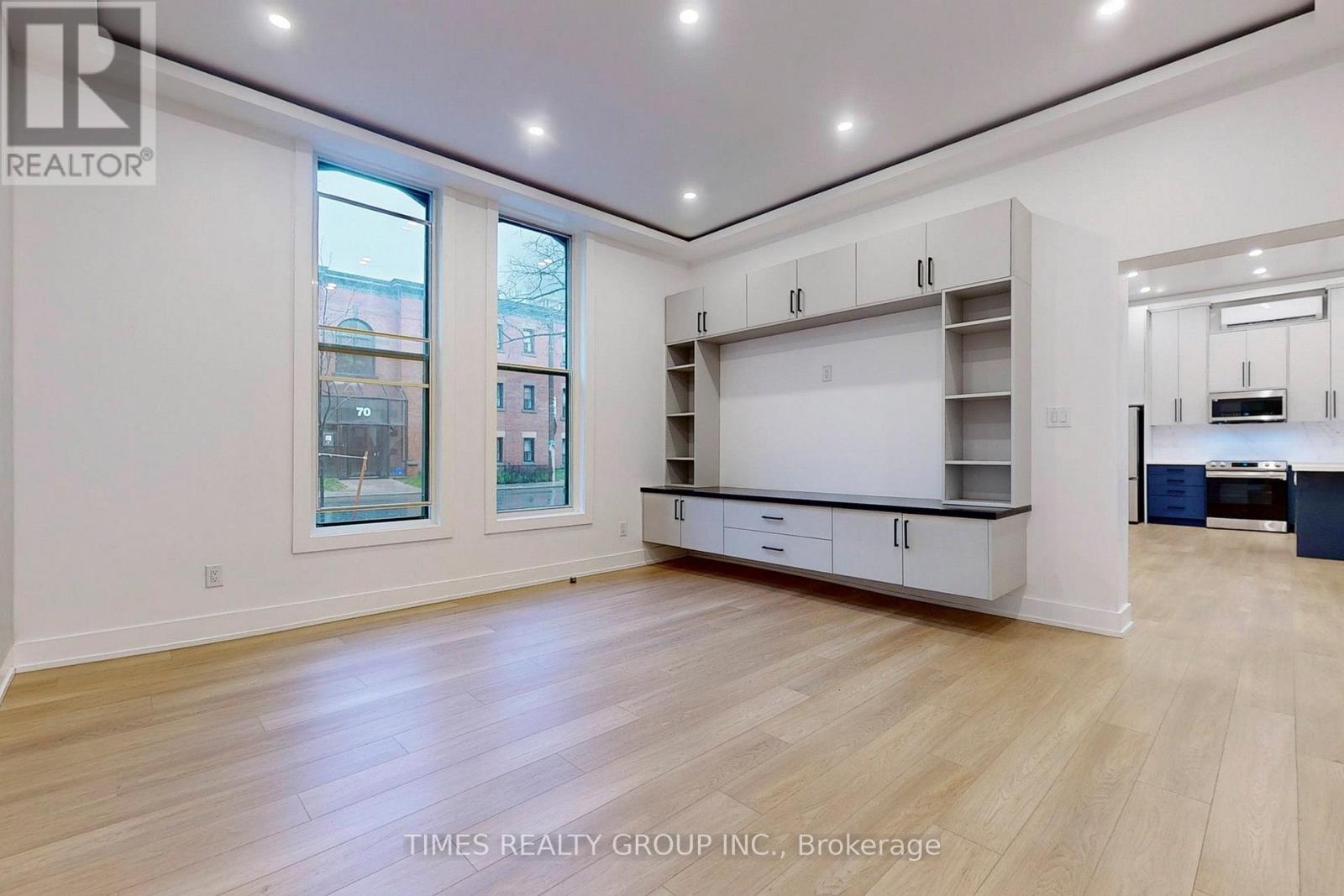 A spacious room with wooden flooring and white walls.