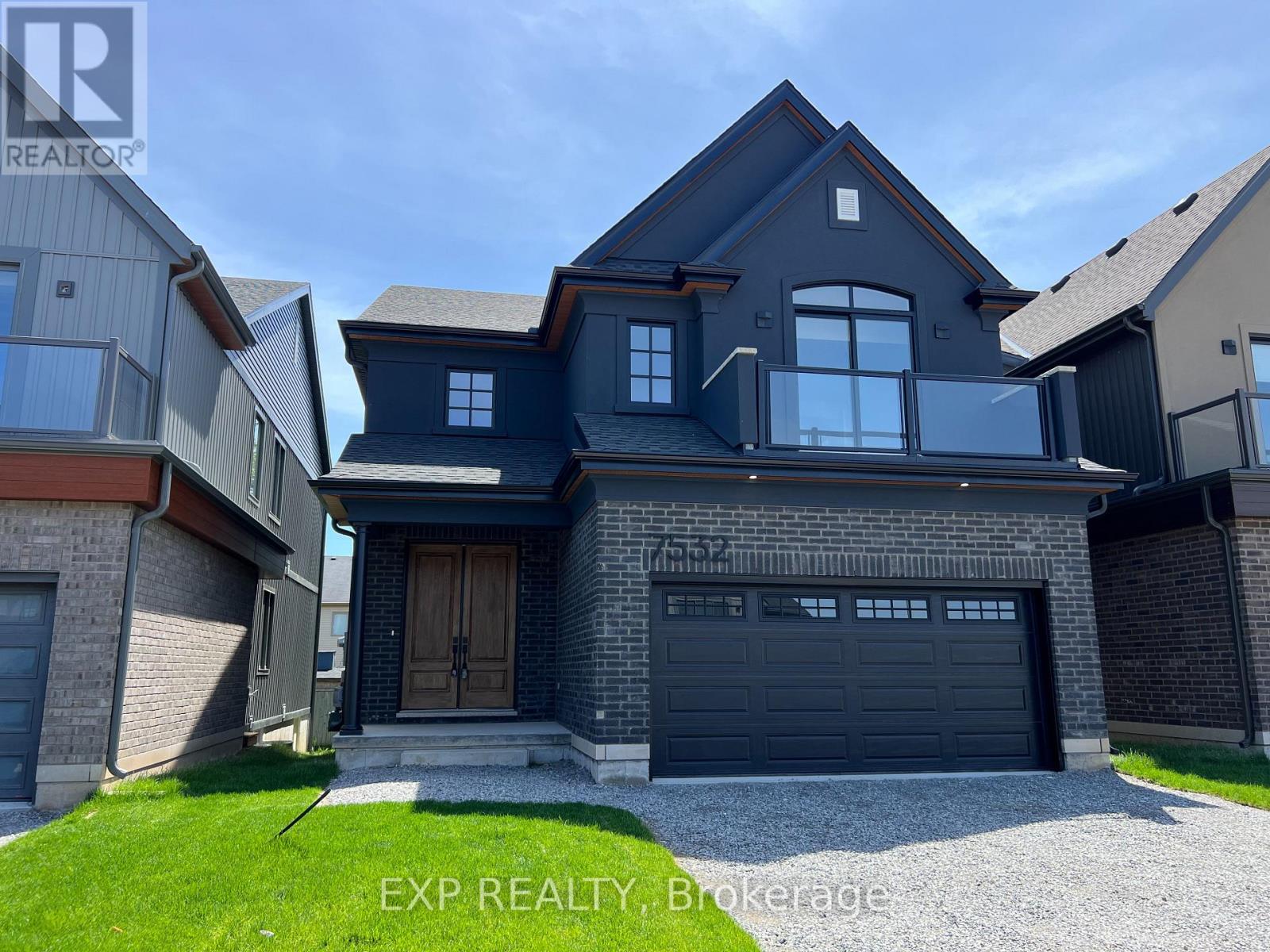 A modern house with a large front yard and a garage.
