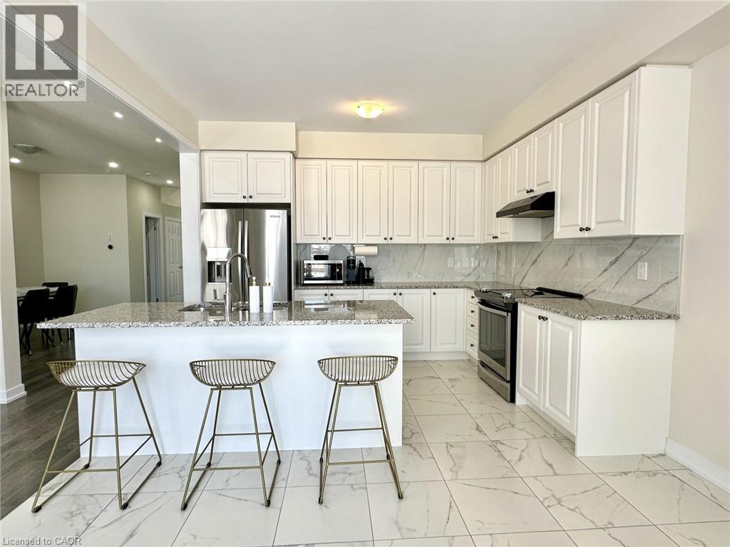A kitchen with white cabinets and a marble countertop.