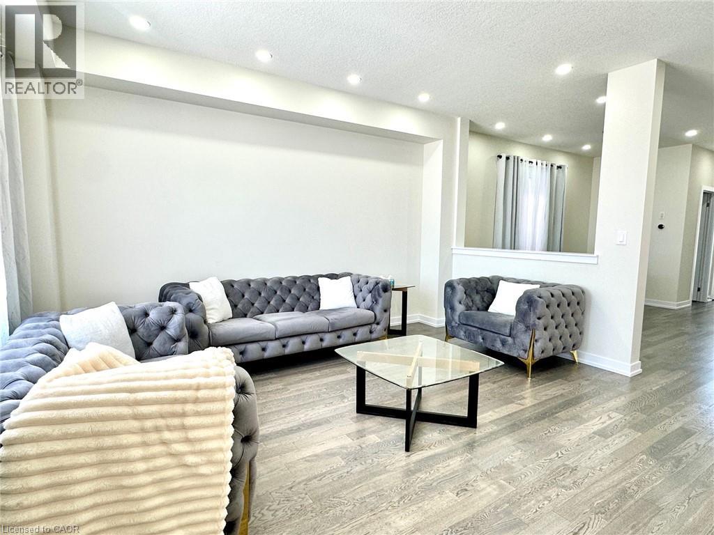 A living room with grey couches and a glass coffee table.