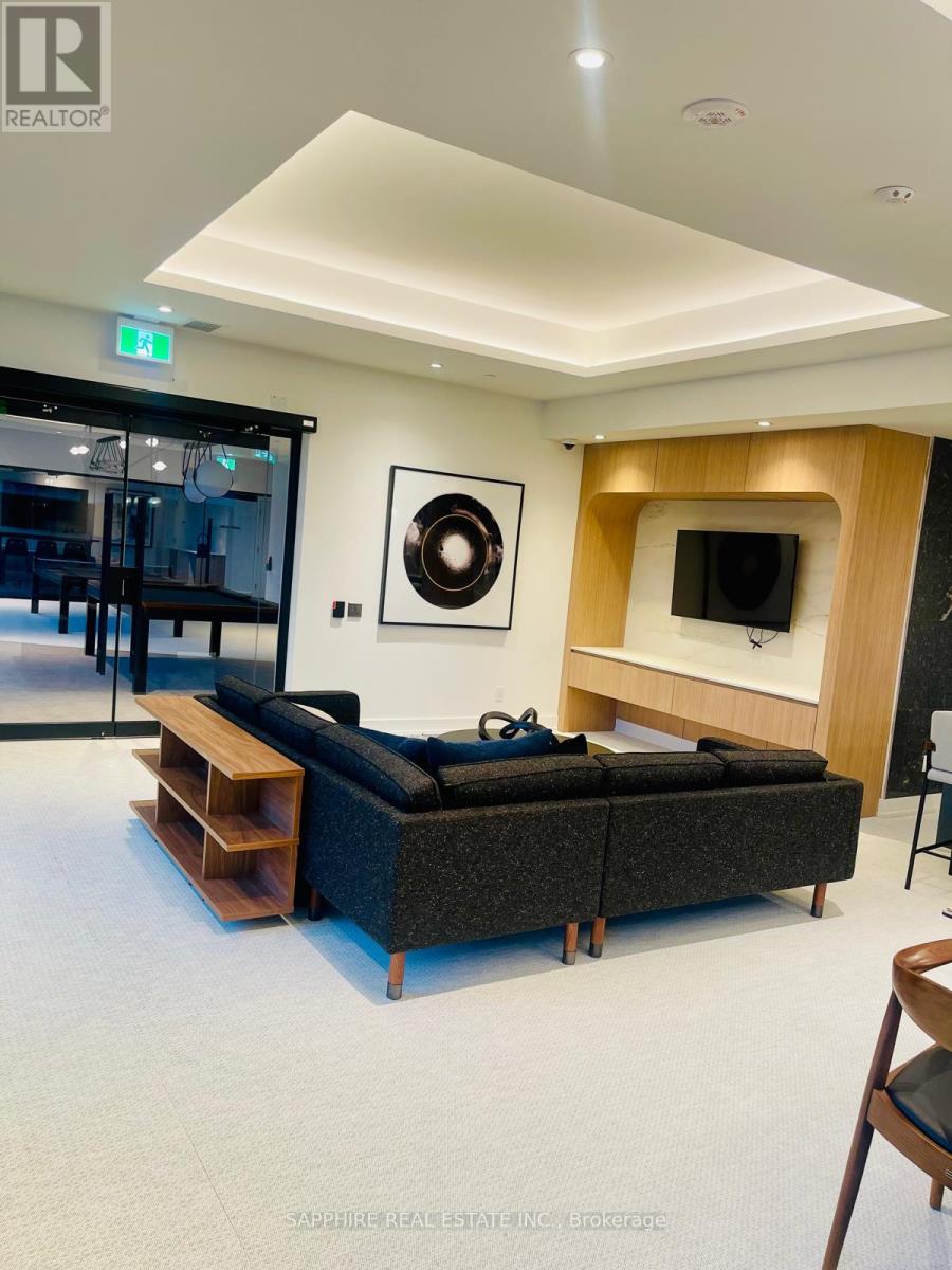 A modern living room with a black couch and a television.