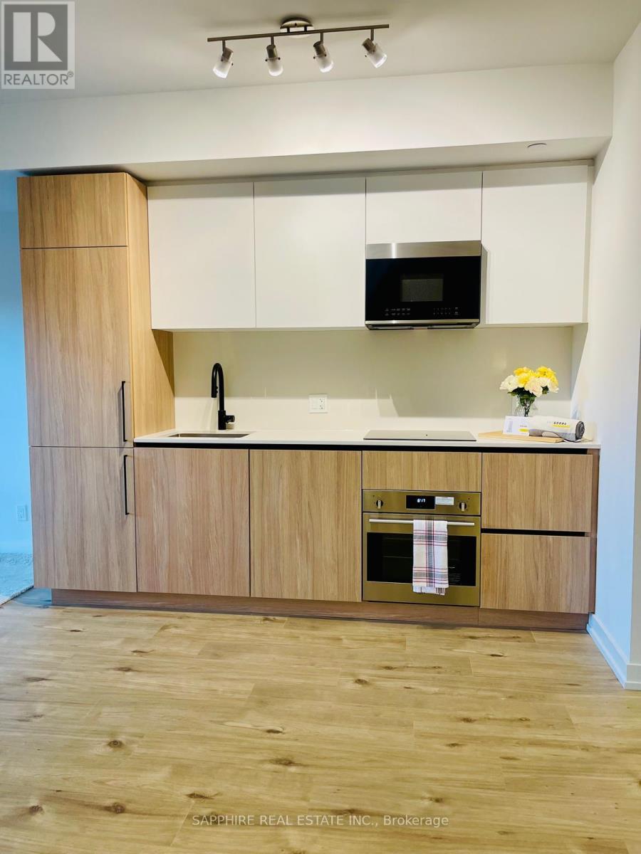 A modern kitchen with wooden cabinets and a microwave above the stove.