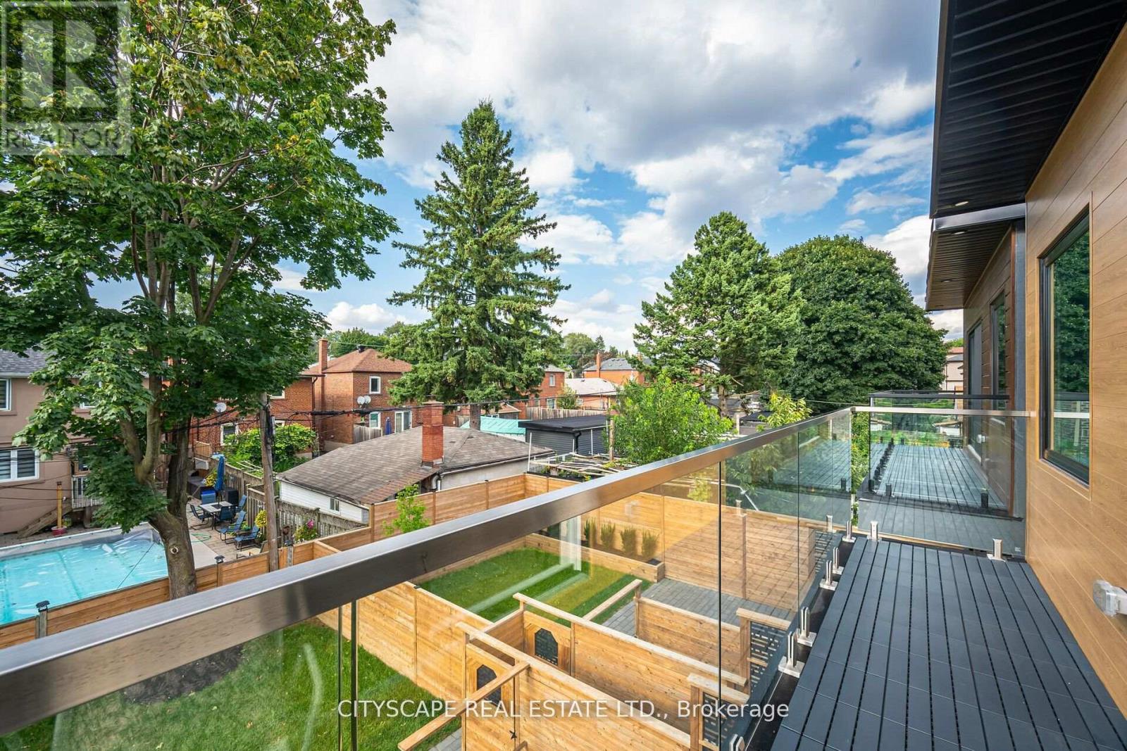 A balcony overlooks a pool and a backyard.