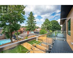 A balcony overlooks a pool and a backyard.