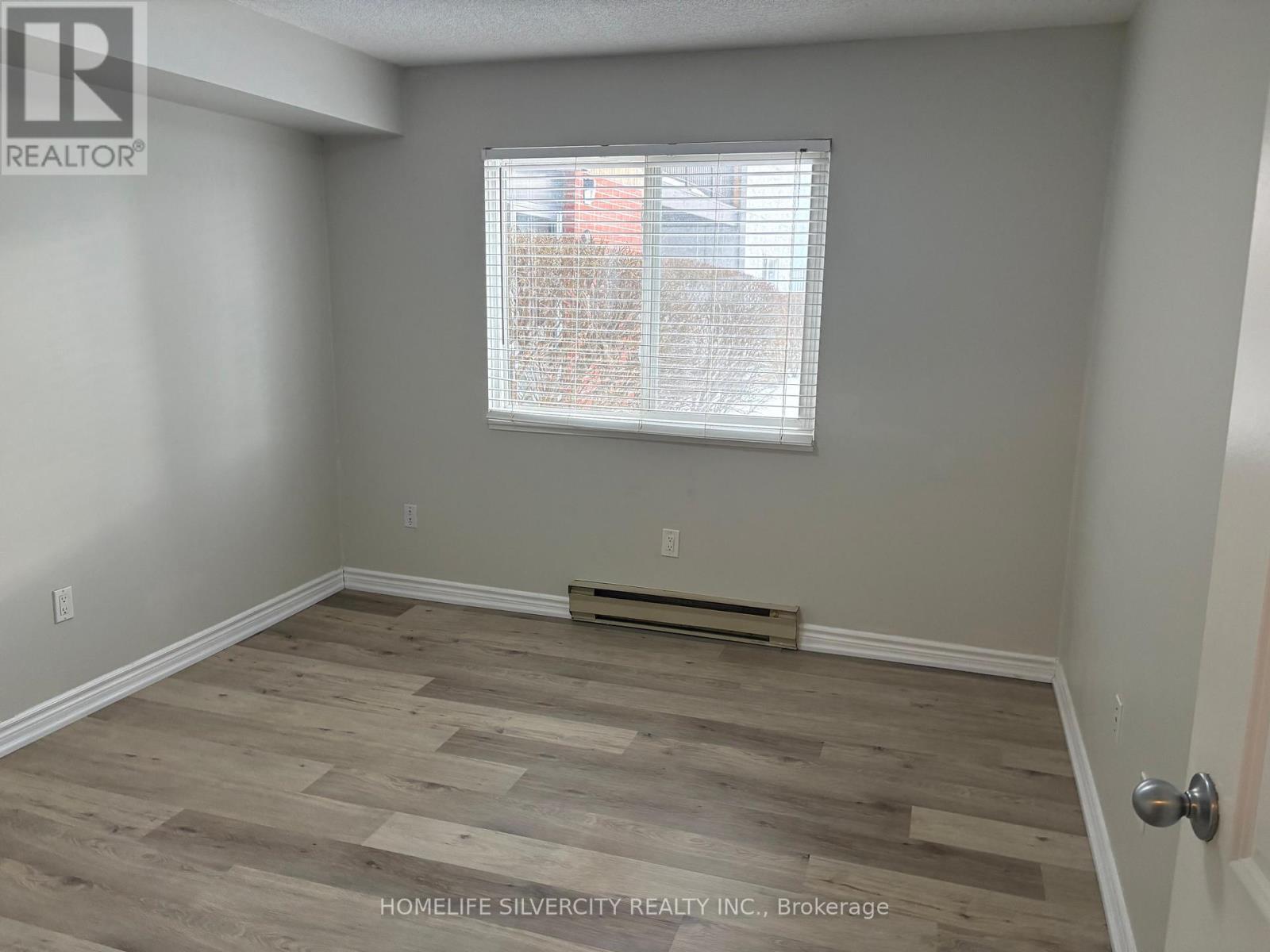 A room with a window and wooden flooring.