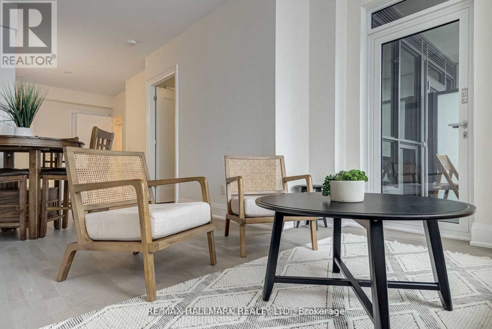 A living room with a black table and two chairs.