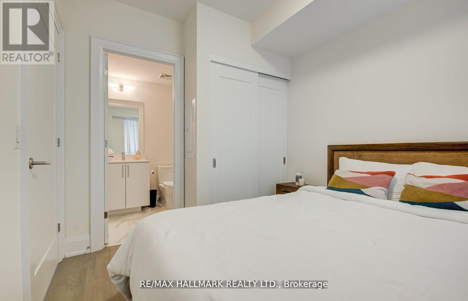 A bedroom with a large bed and a wooden headboard.