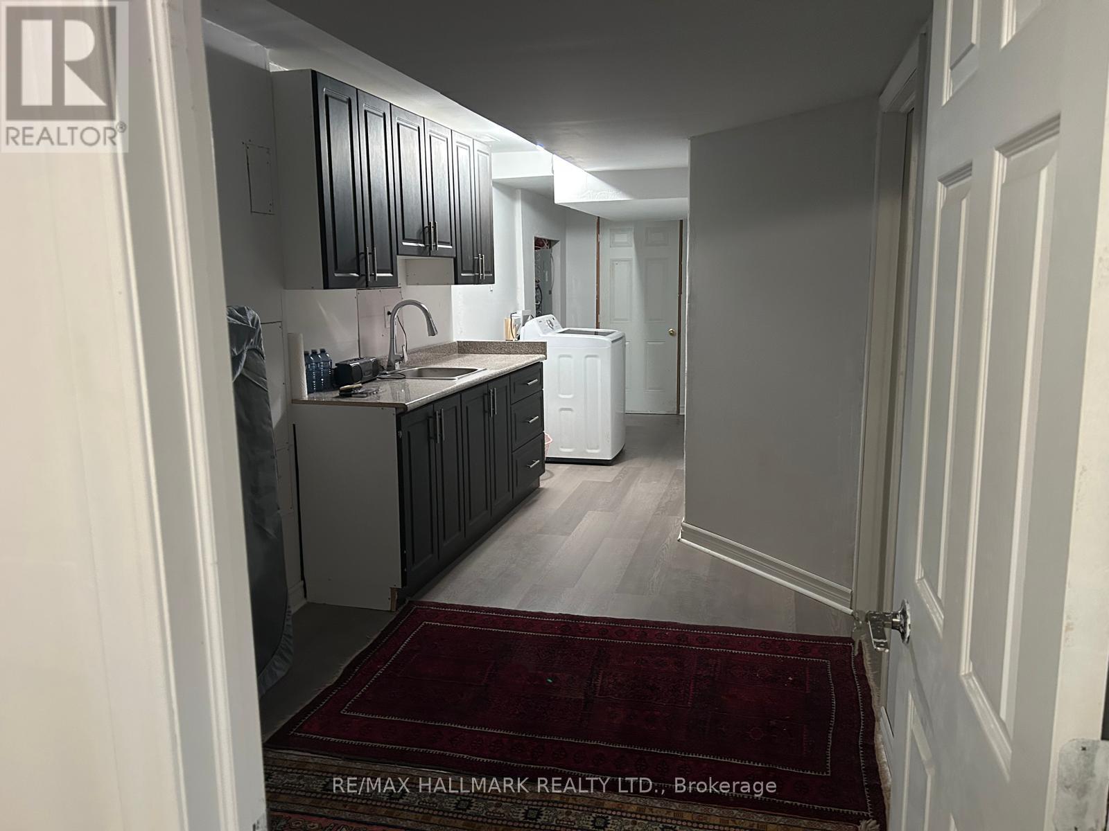 A kitchen with a sink and a refrigerator in a house.