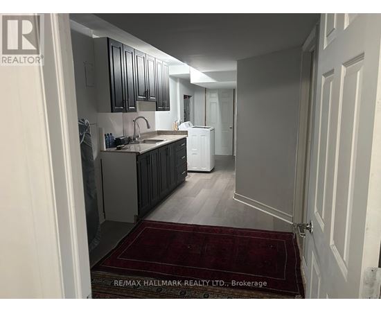 A kitchen with a sink and a refrigerator in a house.