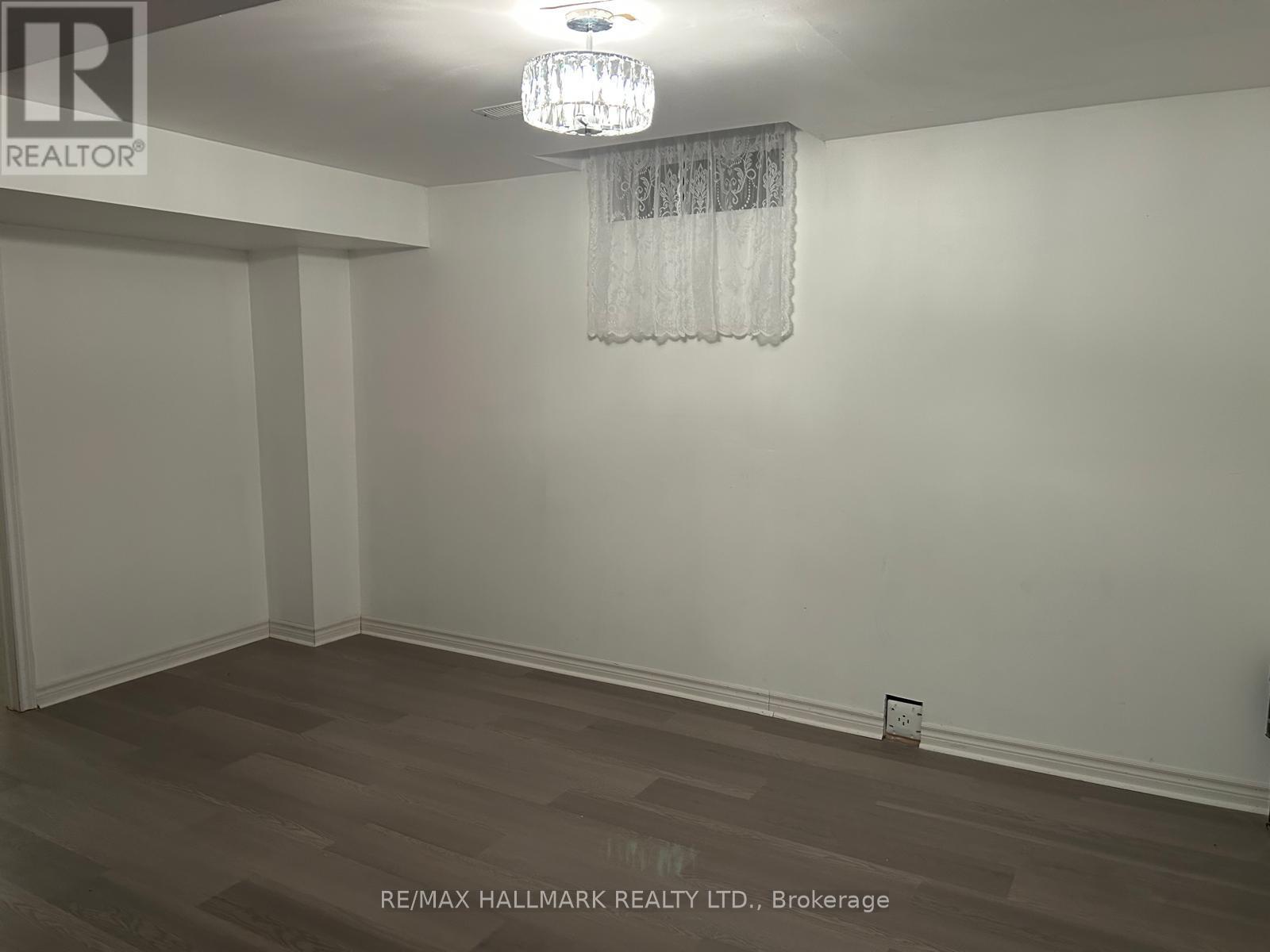 A room with a chandelier and a wooden floor.