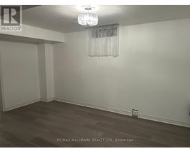 A room with a chandelier and a wooden floor.
