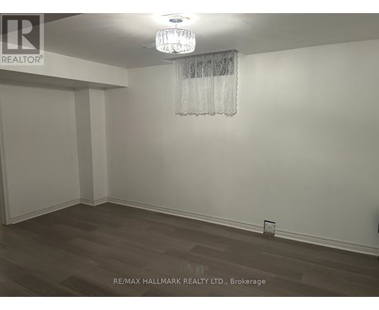 A room with a chandelier and a wooden floor.