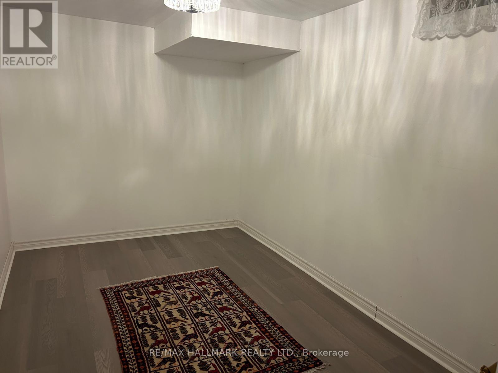 A room with a rug on the floor and a chandelier hanging from the ceiling.