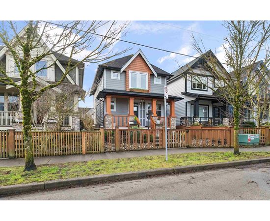 A row of houses with a fence in front.
