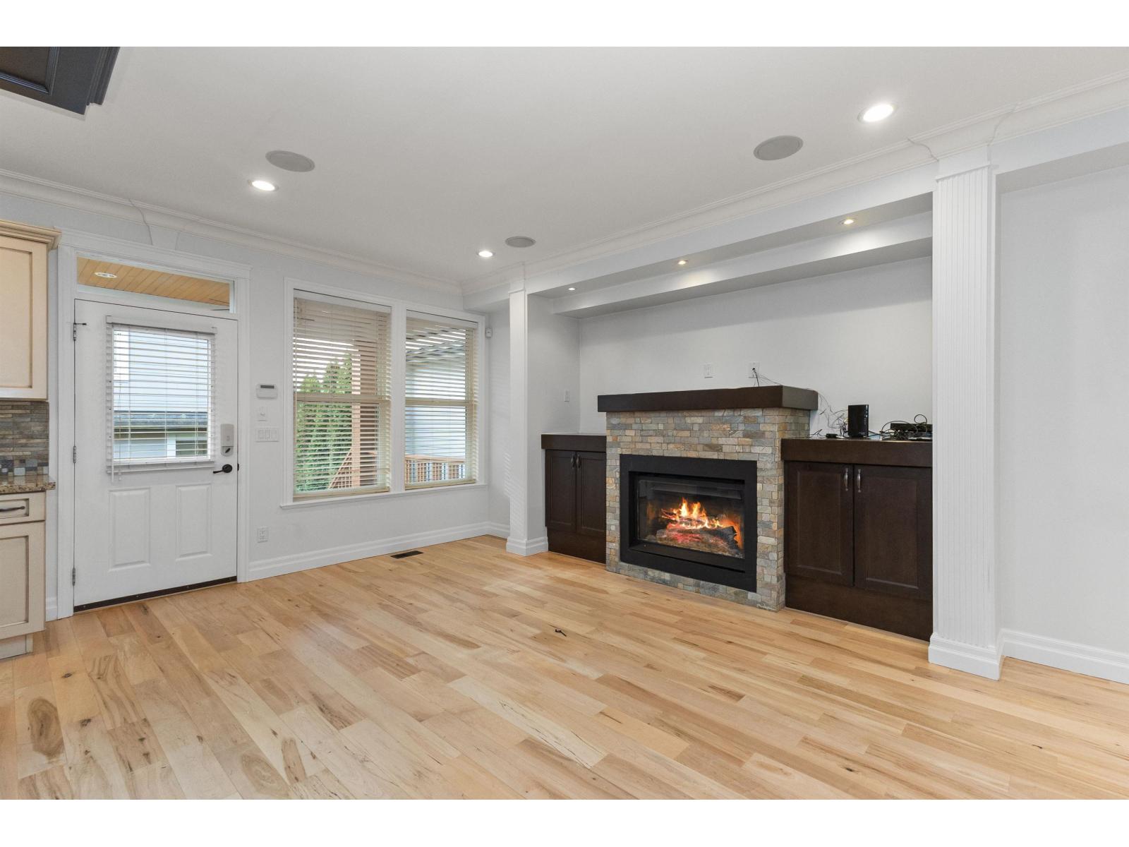 A living room with a fireplace and wooden floors.