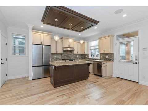 A kitchen with wooden floors and a center island.