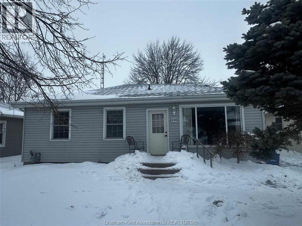 A house with a snow-covered front yard.