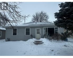A house with a snow-covered front yard.