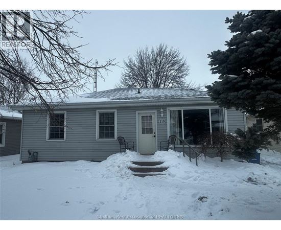 A house with a snow-covered front yard.