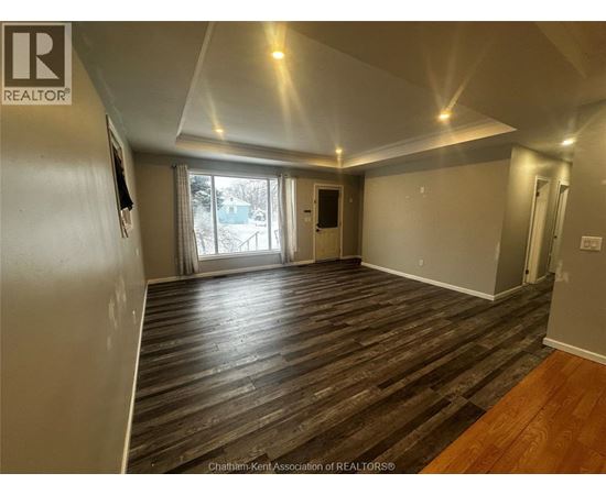 A room with wood flooring and a slanted ceiling.