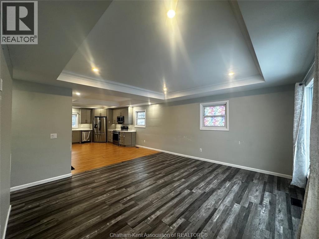 A spacious room with wooden flooring and a stained glass window.