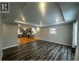 A spacious room with wooden flooring and a stained glass window.