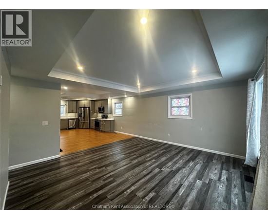 A spacious room with wooden flooring and a stained glass window.