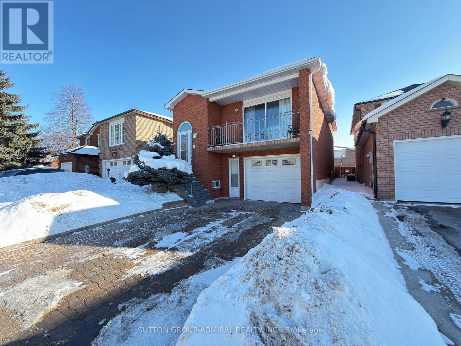 A house with a snow-covered driveway in front of it.