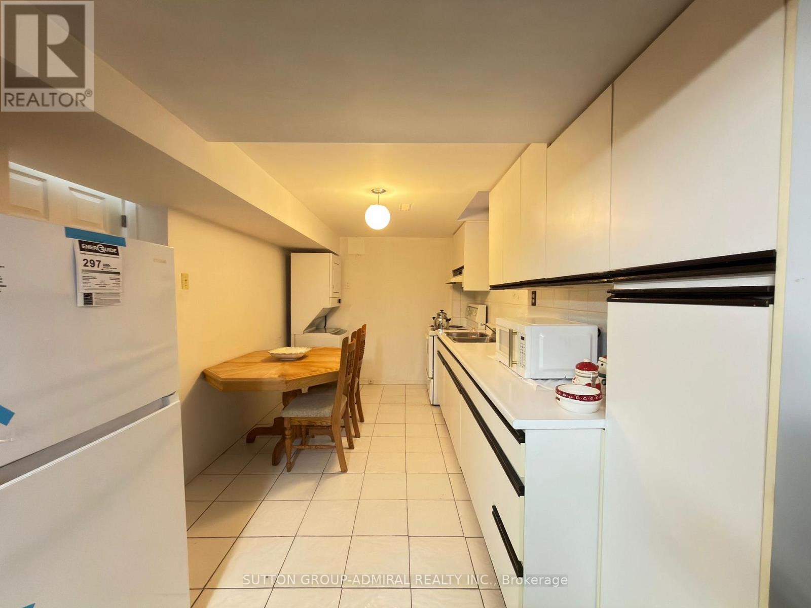 A kitchen with white cabinets and a table with chairs.