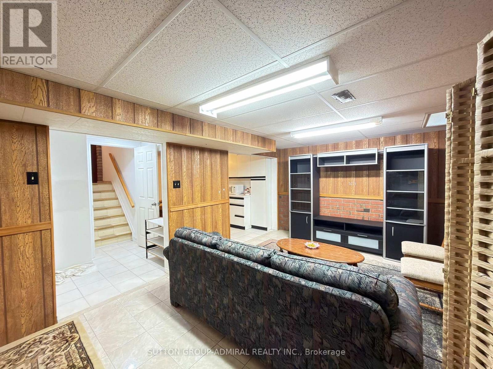 A living room with a couch and a staircase.