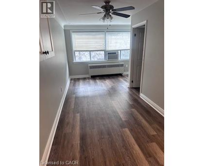 A room with wood flooring and a ceiling fan.