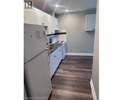 A kitchen with white cabinets and a white fridge.