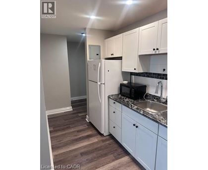 A kitchen with white cabinets and a white fridge.