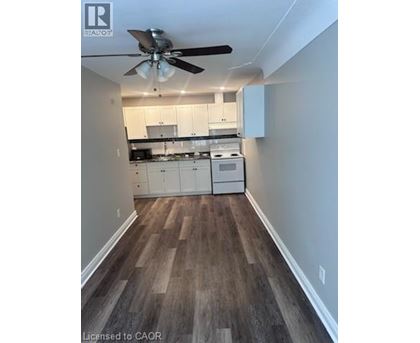 A kitchen with white cabinets and a wood floor.