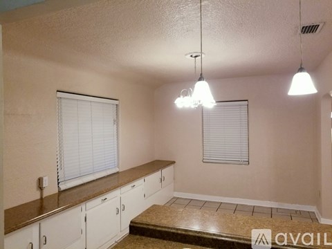 A kitchen with white cabinets and a brown countertop.