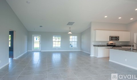 A spacious kitchen and living room with a large island and a dining area.