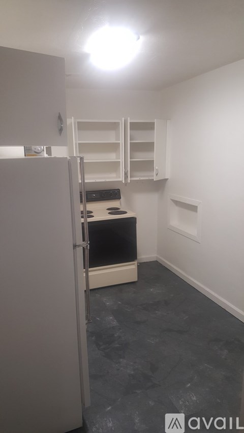A kitchen area with a refrigerator, oven, and cabinets.