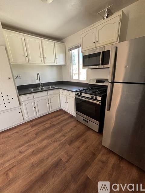A kitchen with wooden floors and stainless steel appliances.