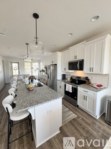 A modern kitchen with white cabinets and a granite countertop.
