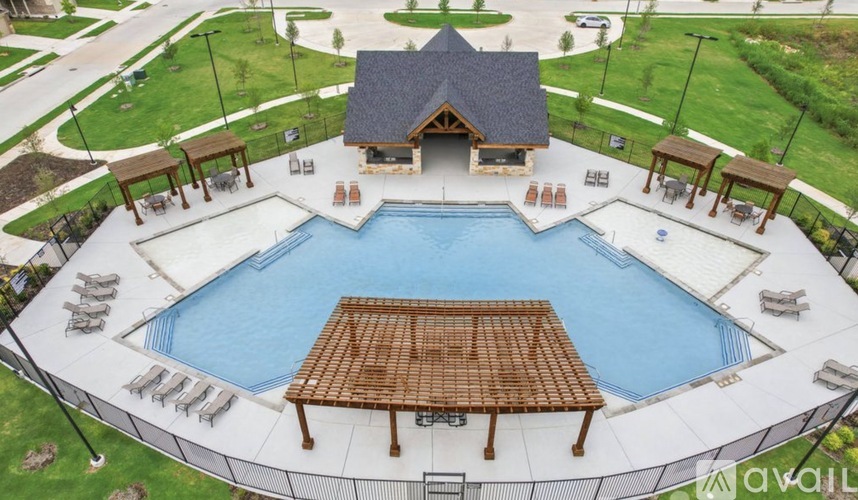 A large outdoor swimming pool surrounded by a deck and pavilion.