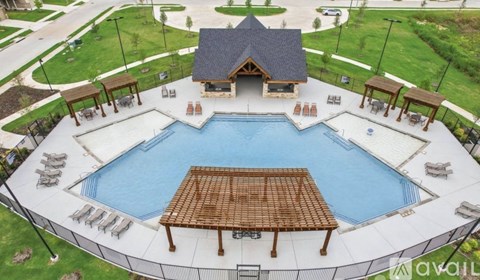 A large outdoor swimming pool surrounded by a deck and pavilion.