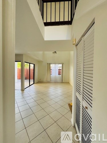 A hallway with white walls and a tiled floor.