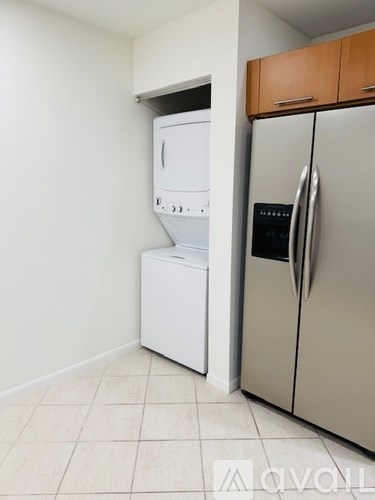A kitchen with a white dishwasher and a silver refrigerator.