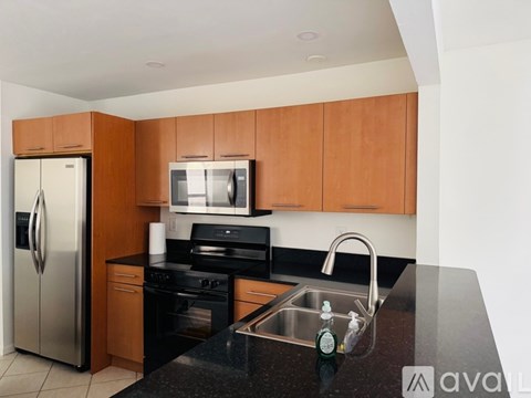 A kitchen with a black counter top and wooden cabinets.