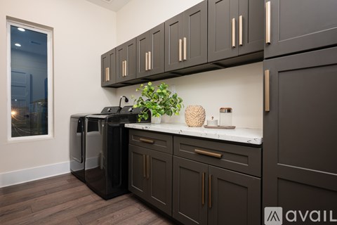 A kitchen with dark brown cabinets and a black countertop.