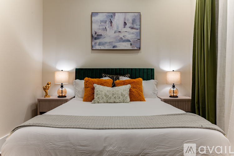 A bedroom with a large bed and a painting on the wall.